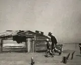 Dust Bowl migrants walk past a dilapidated shack in this iconic Arthur Rothstein photo, a stark reminder of hardship.