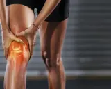 Sportlerin hält schmerzendes Knie, das rot leuchtet. Deutliche Knieschmerzen innenseite.