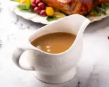 Saucière en porcelaine remplie d'une sauce pour dinde succulente, prête à accompagner le festin de Noël.