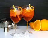 Deux Aperol Spritz prêts à déguster, avec des oranges fraîches et des glaçons. La recette parfaite pour un apéritif ensoleillé.