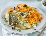 Gebratenes Fischfilet mit Spiralnudeln aus Karotten und Zucchini, garniert mit Kräutern und Mandelsplittern. Perfekt für leichte fasten rezepte.