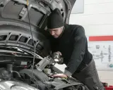 Mechanik z latarką bada silnik 1.6 TDI.