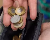 Dłoń z monetami i banknotami w portfelu. Czy to wystarczy na emeryturę po 40 latach pracy? Kalkulator emerytalny pomoże to sprawdzić.