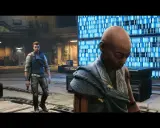 Młody jedi ocalały, Cal Kestis, stoi w hangarze obok tajemniczej postaci z tatuażami na twarzy, na tle niebieskiego, pulsującego ekranu.