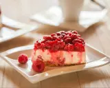 Pyszny sernikobrownie z malinami na białym talerzyku, ozdobiony świeżymi malinami.