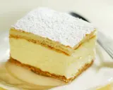 Szybkie ciasto z budyniem, kremowe i puszyste, posypane cukrem pudrem. Idealne na deser.