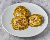 Tres alcachofas cortadas en rodajas, cocinadas a baja temperatura, con un toque de sal marina, servidas en un plato blanco.