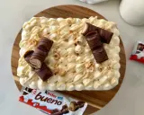 Un délicieux tiramisu Kinder Bueno, garni de morceaux de chocolat et de noisettes concassées. Un vrai régal pour les gourmands !