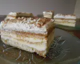 Szybkie ciasto z masą krówkową i budyniem, przełożone kremem, posypane wiórkami. Idealne na deser.