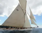 Le voilier "Moonbeam 4" navigue sur une mer agitée, ses voiles blanches gonflées par le vent.