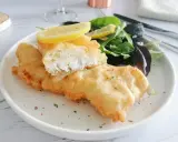 Poisson pané croustillant, servi avec une salade verte et des quartiers de citron. Un délice de fish and chips !