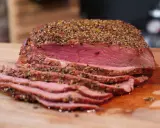 Perfekt gegrilltes Roastbeef mit kräftiger Gewürzkruste, saftig rosa geschnitten auf einem Holzbrett. Ein Genuss für jeden Grillmeister!