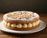 Gâteau dacquoise aux amandes, garni de crème onctueuse et saupoudré de sucre glace. Une délicieuse recette à essayer !