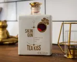 Flasche "Skin Gin Tea Kiss" neben einem goldenen Frosch und Kerzenhalter. Die Frage, wie viele Gin-Sorten es gibt, bleibt offen.