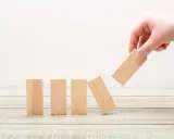 Main d'une personne retire un bloc de bois, faisant tomber les autres. Une métaphore des percers narcissiques qui déstabilisent leur entourage.