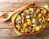 Un plat de pommes de terre et de viande mijotée, garni d'herbes fraîches, une spécialité alsace réconfortante.