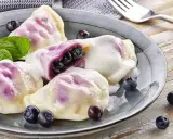 Pyszne pierogi z jagodami, polane śmietaną, z miętą i świeżymi owocami. Idealny przepis na lato!
