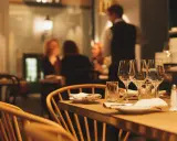 Ett dukat bord med vinglas och servetter, redo för en matvandring i Stockholm. I bakgrunden syns gäster och personal i en mysig restaurangmiljö.