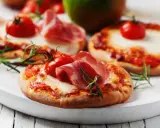 Pizzerinki z serka wiejskiego, pomidorkami koktajlowymi i szynką parmeńską, ozdobione rozmarynem.