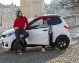 Młoda para przy białym samochodziku, marząca o zdobyciu prawa jazdy AM.