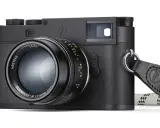 Leica M11 Monochrom, cámara negra con lente Summilux-M 50mm f/1.4 y correa de cuero.