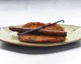Torrijas de leche y canela, doradas y crujientes, con una rama de canela y vainilla. ¡Perfectas para aprender como hacer torrijas de leche y canela!