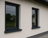 Nowoczesne okna z ciemnymi ramami i parapetami zewnętrznymi, idealne do każdego domu.