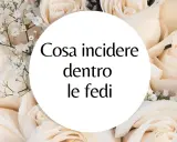 Un cerchio bianco su uno sfondo di rose color crema con la domanda: "Cosa incidere dentro le fedi?". Ispirazione per incisioni fedi nuziali frasi.