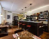Mysig vinbar med trägolv, bardisk och hyllor fyllda med flaskor. Perfekt för att läsa bouchon recensioner över ett glas vin.