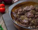 Carrilleras de ternera estofadas con romero y cebolla, listas para servir.