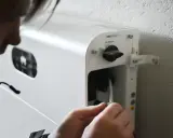 Person kopplar in en kabel i ett vitt system för att lagra solenergi batteri.