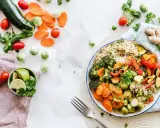Kolorowa miska pełna warzyw i kaszy, idealna na dietę 1500 kcal. Obok świeże warzywa i limonka.