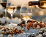 Un verre de vin blanc est versé sur un plateau de fruits de mer frais. Le meilleur vin blanc pour fruits de mer, une combinaison parfaite pour un repas d'été.