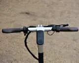 Guidon d'une trottinette électrique, avec écran digital affichant la vitesse et l'autonomie. La hauteur du guidon est idéale pour une conduite confortable.