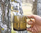 Frisch gezapftes Birkenwasser tropft in eine Tasse. Die natürliche Birkenwasser Wirkung ist bekannt für ihre erfrischenden und belebenden Eigenschaften.