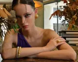 Modella con gioielli in oro e argento rosa, un bracciale, un anello e orecchini che sembrano quasi rovinarsi sotto la luce.