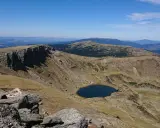 Paisaje montañoso con un lago azul en un valle, ideal para senderismo Soria.