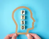 Klocki z literami P, T, S, D układają się w napis PTSD wewnątrz sylwetki głowy. Zrozumienie, ptsd co to, jest kluczowe dla pomocy.