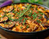 Ein köstlicher griechischer Auflauf Moussaka, mit Auberginenscheiben, Hackfleisch und Käse überbacken, garniert mit Rosmarin und Schnittlauch.