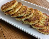 Six galettes de pomme de terre dorées et croustillantes, disposées sur un plat blanc festonné, prêtes à être dégustées.