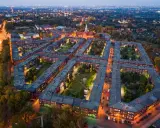 Osiedle Nikiszowiec w Katowicach nocą, z charakterystyczną zabudową i oświetlonymi oknami.