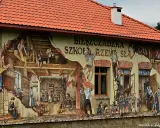 Mural przedstawiający sceny z życia szkoły rzemiosła, z ludźmi pracującymi i uczącymi się.