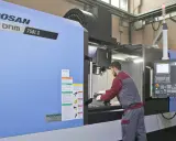 Operaio lavora su centro di lavoro CNC, strumento essenziale per il software progettazione e la produzione di precisione.