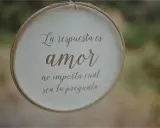 Bordado con "La respuesta es amor, no importa cuál sea la pregunta", ideal para frases cortas para felicitar bodas.