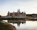 Kalmar Slott, ett populärt utflyktsmål, speglar sig i vattnet en stilla kväll.