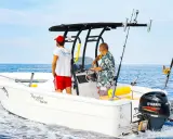 Deux hommes sur un bateau de pêche, avec un roll bar pour bateau, profitent de la mer bleue.