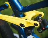 Żółte ramię przerzutki z napisem "PRO LEVER 180MM" na tle niebieskiej ramy roweru. To połączenie zapewnia doskonały reach i stack, a także wzrost wydajności.