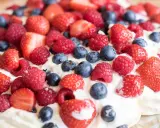 En härlig pavlova med vispgrädde och massor av färska bär. Ett perfekt pavlova recept för sommaren!