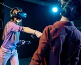 Para grająca w gry na Google VR, zanurzona w wirtualnej rzeczywistości, z kontrolerami w dłoniach.