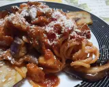 Un piatto invitante di pasta alla norma con melanzane fritte, sugo di pomodoro e ricotta salata grattugiata.